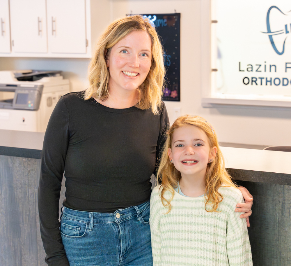Smiling mother and young daughter in the Lazin Family Orthodontics lobby